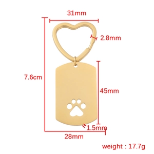 Gold hollow dog paw keychain tag with dimensions and heart ring on white background