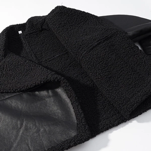 Close-up of black PU leather and soft shearling texture on the lapel of a winter jacket