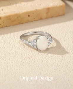 Macro detail of oval white opal ring with side accent diamonds in silver setting