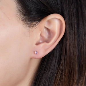 Close-up of minimalist gold S925 silver stud earring with a round purple zircon stone