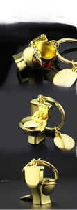 Makro-Detail der goldenen Toiletten-Schlüsselanhänger mit 45-Grad-Klappdeckel und Politur