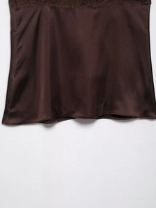 Détail du tissu en satin marron foncé avec bordure en dentelle et texture lisse