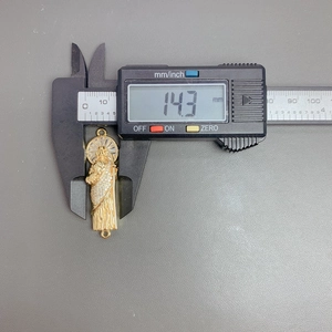 Macro shot showing the 14.3mm width measurement of the Saint Jude pendant charm