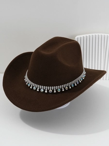 Detail of dark brown western cowboy hat with silver beads and colorful rhinestone band