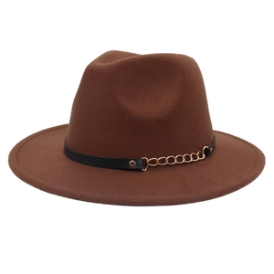Detail of brown wool fedora hat featuring a black leather band and gold metal chain