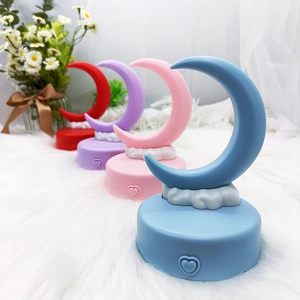 DIY crescent moon night lights in blue, pink, purple, and red on a soft plush base