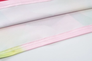 Detailed close-up of gradient pink and green floral print fabric with dual-needle stitching