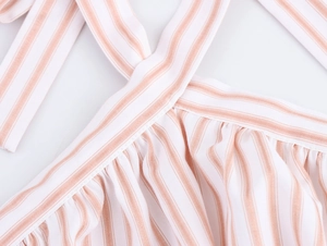 Detail of pink and white vertical stripes with pleated fabric and criss-cross straps
