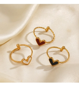 Detailed view of heart-shaped enamel rings in red, white marble, and black on silk