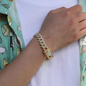 Close-up of a gold-plated Cuban link chain with a sparkling rhinestone-set square clasp