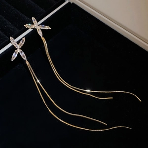 Détail des boucles d'oreilles à franges dorées avec papillon en zircon sur velours
