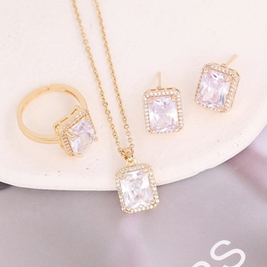 Elegant gold jewelry set with emerald-cut cubic zirconia necklace, ring, and earrings
