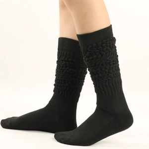 Detailed close-up showing the thick cable knit texture and ribbed cuff of black slouch socks