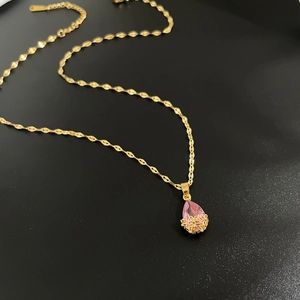 Vue détaillée du pendentif cristal rose goutte d'eau avec base dorée ajourée