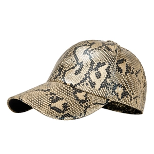 Fashionable faux leather baseball cap with gold and black snakeskin pattern on white background
