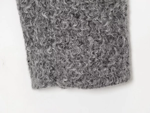 Gros plan détaillé sur la texture douce d'une veste en fausse fourrure grise bouclée