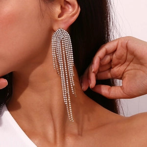 Macro detail of 18K gold-plated tassel earrings with sparkling zircon on a female model