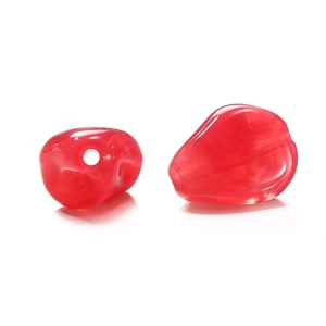 Macro detail of red irregular acrylic beads with translucent finish and smooth texture