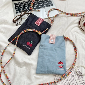 Detail view of cute embroidered denim crossbody bags with colorful braided rope straps