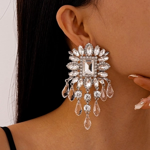 Macro detail of luxury crystal flower earrings with long shimmering tassel chains