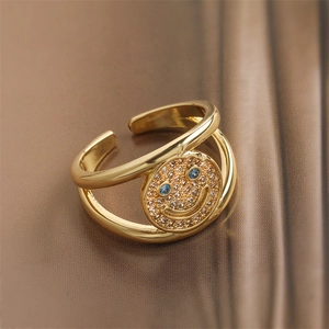 Detail shot of golden double-layer smile ring with blue zircon eyes on brown satin