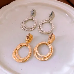 Luxe layered circular dangle earrings in gold and silver finish with hammered metal texture
