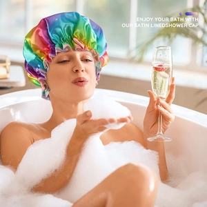 Rainbow satin shower cap shown on a model relaxing in a bubble bath scene