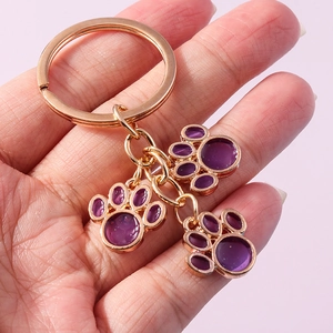 Cute golden cat paw keychains with purple resin pendants for bags and backpacks