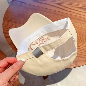 Detail of beige baseball cap featuring internal stitching, classic lining and metal buckle