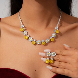Detailed close-up of luxury flower necklace and earrings set worn with red velvet dress