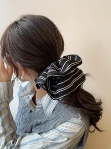 Detailed view of an oversized striped scrunchie on a stylish ponytail hairstyle
