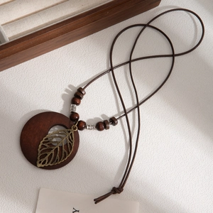 Vintage bohemian long necklace with dark wood circle, bronze leaf charm and leather cord