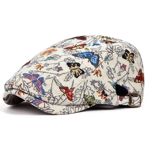 Détail du béret vintage avec broderie papillon colorée et boucle métallique réglable