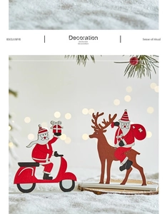Detail of wooden Santa on a red scooter and reindeer ornaments with a festive bokeh background