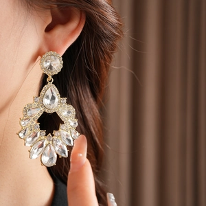Gros plan de boucles d'oreilles goutte dorées avec strass marquise et poire étincelants