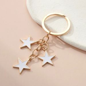 Golden keychain with three white enamel star charms dangling from a polished metal split ring