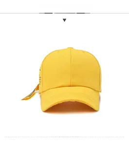 Front view of yellow cotton baseball cap with ribbon detailing and black lettering