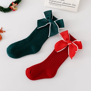 Red and green Christmas baby knee-high socks with large bows and festive decorations
