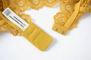 Close-up of yellow floral lace bra tag showing UK 34 size and fabric composition details
