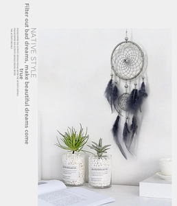Macro view of handcrafted grey dreamcatcher with twin rings, feathers and beads decoration