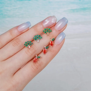 Elegant gold and silver tree stud earrings with green crystals and red fruit piercing jewelry