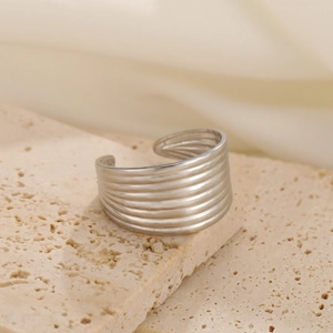 Macro shot of silver textured layered stainless steel adjustable ring on stone surface