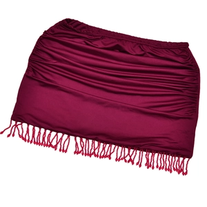 Détail d'une mini-jupe bordeaux avec texture froncée et bordure à franges sur fond blanc
