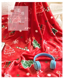 Detail of soft red Christmas flannel blanket with festive tree and snowflake patterns