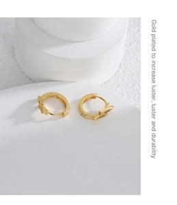 Detail of gold-plated earring with zircon inlay showing luster and durability texture