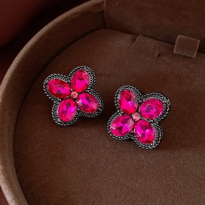 Macro shot of dark pink crystal clover earrings with beaded edge and grey metal base