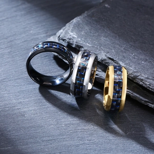 Detailed view of 8mm men's rings in black, silver, and gold with blue carbon fiber inlay