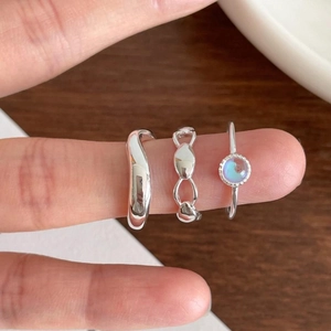 Close-up of 925 sterling silver ring set featuring a wave band and round gemstone detail