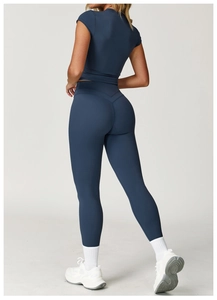 Rear view of navy blue high-stretch yoga set with tight short-sleeve top and leggings