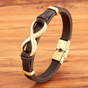 Brown braided leather bracelet with golden infinity symbol on a rustic wood background
